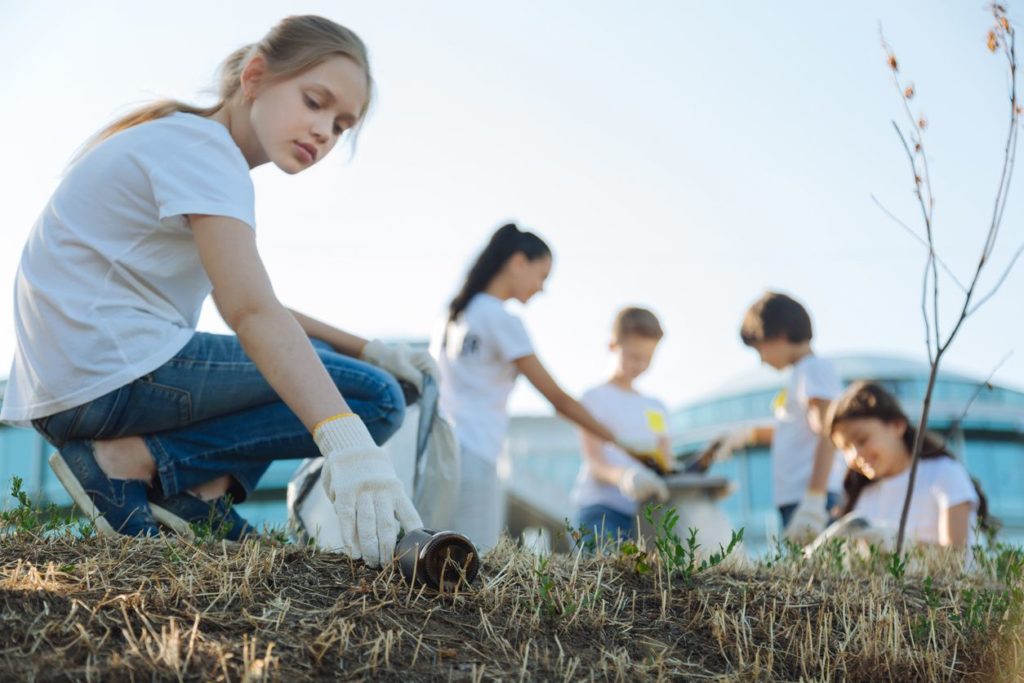 Kids working together to clean up trash on the beach